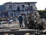 Pessoas caminham por entre os escombros em Minamisoma, Fukushima