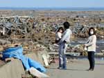 Moradores de Minamisoma, na provncia de Fukushima, olham o resultado da destruio causada por um tsunami na sexta-feira (11)