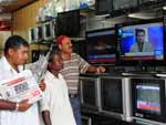 Em uma loja de material eltrico, paquistaneses assistem ao noticirio que mostra a morte de Bin Laden
