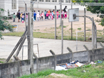 Enquanto usam o crack, crianas brincam no outro lado do muro.