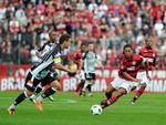 Joo Paulo Goiano avana com a bola, observado por Ronaldinho Gacho