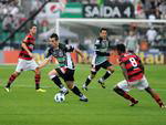 Elias carrega a bola com a perna esquerda, cercado por Thiago Neves e Williams