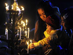 Indianos acendem velas em frente  esttua de Jesus na igreja de Santa Maria