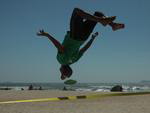 O professor de surfe Samuel Arajo faz acrobacias no slackline na areia da Gamboa