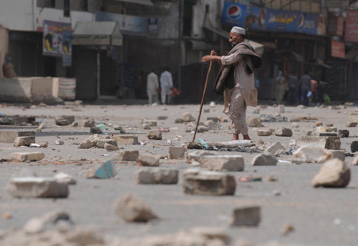 Um mendigo cego tenta fazer seu trejeto atravs de pedaos de rocha e pedras espalhados pela rua devido troca de tiros entre a policia e grupos criminosos no Paquisto.