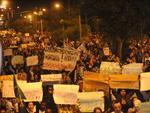 Manifestantes carregam cartazes com mensagens contra o governo