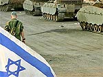 Soldado israelense caminha entre os tanques