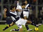 O jogador Rodrigo Palacio (D), do Boca Juniors, briga pela bola com Maximiliano Pellegrino (E), do Vlez