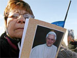 Uma mulher segura uma foto do Papa Bento XVI no Campo de Marte