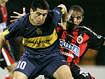 Riquelme(E), do Boca Juniors, escapa de Macnelly Torres(D), do Ccuta