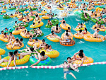 Na sia, onde chuvas torrenciais tm inundado algumas regies, outras reas sofrem com o calor. A foto mostra um grupo de pessoas se refrescando no parque aqutico Dino Beach em Shangai, na China