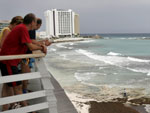 Turistas observam o mar do Caribe de Cancun, no Mxico. O furaco provocou estragos em muitas praias da regio