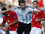 O argentino Gabriel Heinze (C) disputa a bola com Artur Vidal (E), do Chile. A Argentina vence e est na vice-liderana provisria