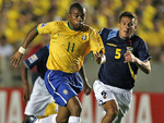 O Brasil comea a partida truncado em campo. S aos seis minutos do primeiro tempo, o time comea a se soltar. Ronaldinho Gacho tenta jogada com Robinho (E). Mas Vgner Love estava impedido