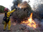 Nos arredores de San Diego, bombeiro utiliza a tcnica de contrafogo para deter os incndios que assolam a regio sul da Califrnia h mais de trs dias