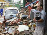 Moradores tentam salvar o que restou no meio dos escombros