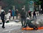 Agentes da polica antidistrbios recebem o impacto de um coquetel molotov durante ato de protesto em frente ao Parlamento grego, em Atenas, nesta quarta-feira (05/05)