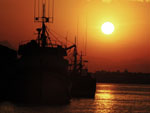 Pr do sol com barcos de pesca atracados no porto pesqueiro de Itaja.